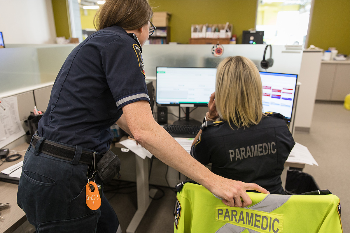 two paramedics in front of computers